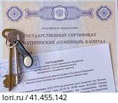 Государственный сертификат материнский (семейный) капитал, соглашение об определении размера долей недвижимого имущества и ключи от дверного замка (2023 год). Редакционное фото, фотограф Цибаев Алексей / Фотобанк Лори