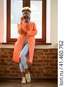 African model woman in orange spring jacket and blue pants. Стоковое фото, фотограф Андрей Аркуша / Фотобанк Лори