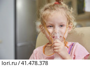 A sick girl breathes with a nebulizer inhaler at home during her illness. Lifestyle. Стоковое фото, фотограф Кутина Татьяна / Фотобанк Лори