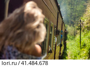 Rear view of woman tourist travel by train to landmarks in Sri Lanka. Traveler lady enjoy extreme fun sri lankan train ride in tropic country. Touristic journey tropical concept. Copy ad text space (2022 год). Стоковое фото, фотограф Aleksandr Golubev / Фотобанк Лори