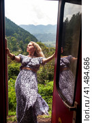Traveler woman tourist hanging from moving train, travelling to sri lankan extreme train. Cute lady enjoying trip ride by landmarks in Sri Lanka. Touristic journey tropical concept. Copy ad text space (2022 год). Стоковое фото, фотограф Aleksandr Golubev / Фотобанк Лори