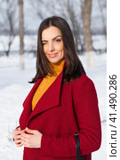 Young beautiful brunette woman in red coat posing on winter park. Стоковое фото, фотограф Андрей Аркуша / Фотобанк Лори