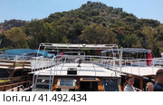 Stock video from the marina of the port of Andriaki, located in the Intourists take seats in the yacht before going to sea. August 12, 2020 Demre. Turkey. Редакционное видео, видеограф Ярославский Максим / Фотобанк Лори