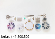 Accessories and supplies for bead embroidery: hoop with felt and mesh, sets of beads and beads, scissors, needles, monofilament and needle threader on white background. Hobbies and handicrafts. Стоковое фото, фотограф Виктория Катьянова / Фотобанк Лори