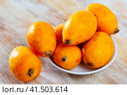 Closeup of whole ripe yellow loquat on wooden table. Vitamin fruits. Стоковое фото, фотограф Яков Филимонов / Фотобанк Лори