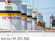 Tank the vertical steel. Capacities for storage of oil products. Caption: flammable. Стоковое фото, фотограф Леонид Еремейчук / Фотобанк Лори