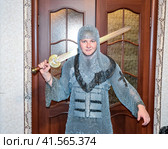 A man dressed up in a knight's hauberk at home in his room. Knight's sword in the hands of a man. Стоковое фото, фотограф Леонид Еремейчук / Фотобанк Лори