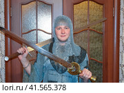 A man dressed up in a knight's hauberk at home in his room. Knight's sword in the hands of a man. Стоковое фото, фотограф Леонид Еремейчук / Фотобанк Лори