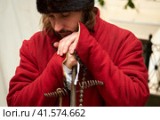Portrait of a male gunner in a vintage Swedish military uniform with a ramrod in his hands. Reconstruction of the events of the Russian-Swedish War. Times and Epochs Festival on the streets of Moscow, Russia, June 13, 2022. Редакционное фото, фотограф Андрей Журавлев / Фотобанк Лори