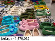 Nizhny Novgorod, Russia - May 29, 2023: felt shoes. Various variants of felted shoes with handmade embroidery. Souvenir products in the store. Редакционное фото, фотограф Оксана Медведева / Фотобанк Лори