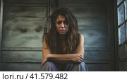 A tired, depressed woman sits on the floor and looks thoughtfully at the camera. Generated by AI. Стоковое AI-изображение, AI-художник Ярославский Максим / Фотобанк Лори