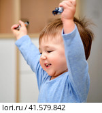 Portrait of a happy toddler baby boy with his hands up. The face of a smiling child with a victorious gesture of upraised hands. Kid aged one year and three months. Стоковое фото, фотограф Андрей Журавлев / Фотобанк Лори