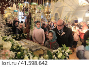 Ребёнок целует плащаницу в Новодевичьем монастыре в Страстную пятницу (2018 год). Редакционное фото, фотограф Дмитрий Неумоин / Фотобанк Лори