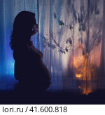 Pregnancy problems in the coronavirus epidemic, concept. Shadow of a woman in a face mask n95 ffp2. Стоковое фото, фотограф Андрей Журавлев / Фотобанк Лори