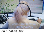 Dispatching service of the Moscow ambulance. Rear view of female customer support operator using headset and computer in call center - Moscow, Russia, August 30, 2023. Редакционное фото, фотограф Андрей Журавлев / Фотобанк Лори