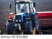 Tractor with a seeder in the field. sowing seeds in the soil. Стоковое фото, фотограф Леонид Еремейчук / Фотобанк Лори