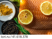 Top view of fresh raw salmon fish steak with spices on a dark stone background. Salt, spices, seasonings and other ingredients. Стоковое фото, фотограф Артем Лукин / Фотобанк Лори