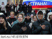 Молодые люди, члены Движение первых поют национальный гимн России во время репетиции музыкального спектакля "1000 первых", который должен состояться в День народного единства во время проведения выставки-форума Россия на ВДНХ в городе Москве, Россия (2023 год). Редакционное фото, фотограф Николай Винокуров / Фотобанк Лори