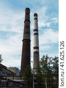 Old plant pipes on blue sky background. Industrial heat-energy center with tall chimney tubes. Стоковое фото, фотограф Константин Григорьев / Фотобанк Лори