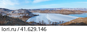 Baikal Lake in December. Panoramic view of the freezing Small Sea, and Kurkut Bay. Top view from the rocky coast to the tourist village with wooden houses near the beach. Стоковое фото, фотограф Виктория Катьянова / Фотобанк Лори
