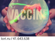 Women hands are guessing about the future of coronavirus vaccination on the ball of fate. Witch over the Crystal Ball predicts the future of the flu virus vaccine. Стоковое фото, фотограф Андрей Журавлев / Фотобанк Лори