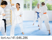 Young woman honing punching techniques during kumite at karate training. Стоковое фото, фотограф Яков Филимонов / Фотобанк Лори