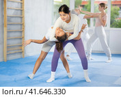 Asian woman practicing reverse headlock in sparring during self-defence training. Стоковое фото, фотограф Яков Филимонов / Фотобанк Лори