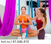 Woman practicing antigravity yoga with personal trainer. Стоковое фото, фотограф Яков Филимонов / Фотобанк Лори