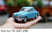 A model of a small car on the arm. Generated by AI. Стоковое AI-изображение, AI-художник Ярославский Максим / Фотобанк Лори