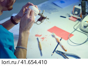 The dentist's hands are working on making denture to replace the patient (2019 год). Редакционное фото, фотограф Андрей Журавлев / Фотобанк Лори