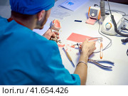 An intern doctor in training trains on the creation of dentures. internship in a clinic with medical students. (2019 год). Редакционное фото, фотограф Андрей Журавлев / Фотобанк Лори