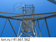 Supports high-voltage power lines against the blue sky. View from the bottom up. Стоковое фото, фотограф Леонид Еремейчук / Фотобанк Лори