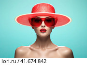 A girl in sunglasses and a watermelon-colored straw hat on a blue pastel background. Стоковое AI-изображение, AI-художник Ярославский Максим / Фотобанк Лори