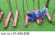 A happy child is playing on the playground crawling through an obstacle course. Kid aged one year four months (16 months) Стоковое видео, видеограф Андрей Журавлев / Фотобанк Лори