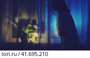 A woman holds her hands on her sore stomach at the night dark window, low key silhouette. The shadow of a female figure with an attack of abdominal pain, stop motion. Стоковое видео, видеограф Андрей Журавлев / Фотобанк Лори
