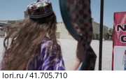 Bukhara Uzbekistan - 7 2 2018: A young woman with long hair in an oriental robe and a skullcap walks through an ancient oriental city (2023 год). Редакционное видео, видеограф Aleksey Kidisyuk / Фотобанк Лори
