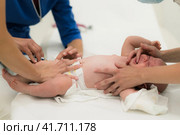 Baby beeing vaccinated by pediatrician in presence of his mother. Preventive vaccination against Diphtheria, whooping cough, tetanus, hepatitis, haemophilus influenzae, pneumococcus, poliomyelitis. Стоковое фото, фотограф Matej Kastelic / Фотобанк Лори
