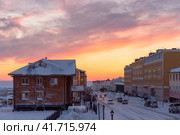Утренний вид на заснеженную улицу северного города в Арктике. Зимний городской пейзаж. Автомобили на улице. Холодная погода. Красивый восход солнца. Город Анадырь, Чукотка, Крайний Север России. Стоковое фото, фотограф Андрей Степанов / Фотобанк Лори