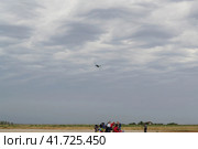 Волгоградская область, Средняя Ахтуба, Россия года. Самолёт Ан-2 и парашютисты в степи, облачное небо перед грозой. (2022 год). Редакционное фото, фотограф Андрей Цыганков / Фотобанк Лори