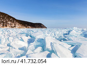 Endless hummock fields with piles of huge transparent blue ice floes at the shore of frozen Baikal Lake near village of Goloustnoye on frosty sunny January day. Beautiful winter landscape. Natural background. Стоковое фото, фотограф Виктория Катьянова / Фотобанк Лори