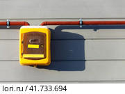 Yellow plastic box with gas flow counter is mounted on wooden house wall, winter season. Стоковое фото, фотограф Кекяляйнен Андрей / Фотобанк Лори