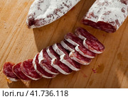 Slicing delicious Spanish smoked sausage fuete. Стоковое фото, фотограф Яков Филимонов / Фотобанк Лори