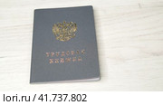 На светлом деревянном фоне трудовая книжка гражданина Российской Федерации с трудовым стажем. Стоковое видео, видеограф Sergei Gorin / Фотобанк Лори