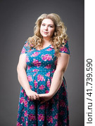 Young beautiful happy blonde plus size model in dres, xxl woman portrait on gray studio background. Стоковое фото, фотограф Станислав Тарко / Фотобанк Лори