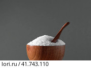 White table salt granules falling into a pile. Wood bowl. Gray color studio background. Condiment particles dropping. Clean cosmetic bath salt pouring footage. Closeup of grained sea salt pieces hill. Стоковое фото, фотограф Марина Демидюк / Фотобанк Лори