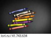 Восемь цветных восковых мелков Crayola россыпью на чёрной поверхности - Россия, Санкт-Петербург, Ноябрь 2023. Редакционное фото, фотограф Мария L. / Фотобанк Лори