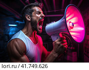 A young enraged man shouts violently into a megaphone. Purple-blue smoke on the background. Generated by AI. Стоковое AI-изображение, AI-художник Ярославский Максим / Фотобанк Лори