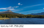 Beautiful lake of Patagonia Lapataia Bay. Ripples on calm blue water. Green forest on the shore. A picturesque mountain on a background of azure sky and clouds. Argentina. Tierra del Fuego. Стоковое фото, фотограф Вера Ивановна Кубарева / Фотобанк Лори