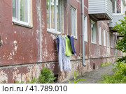 Фасад панельной хрущевки, на котором сушится белье. Россия, Владивосток (2022 год). Стоковое фото, фотограф Денис Станиславович Кабелев / Фотобанк Лори