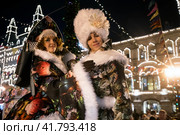 Артисты в разноцветных карнавальных костюмах во время праздничных предновогодних мероприятий на ГУМ-ярмарке на Красной площади в центре города Москвы, Россия (2023 год). Редакционное фото, фотограф Николай Винокуров / Фотобанк Лори